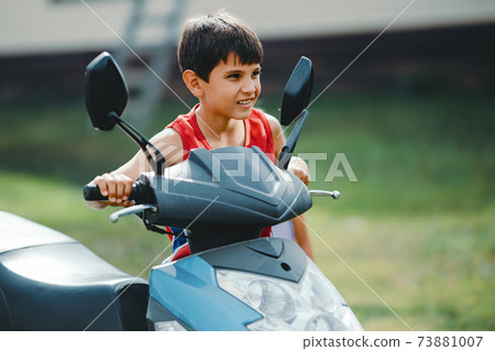 A boy drives a scooter or a small bike. The Stock Photo