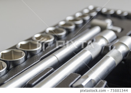 Set of tools closeup - wrench heads, nozzles the screwdriver in case. Professional instrument. Selective focus. 73881344