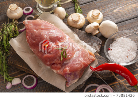 pork tenderloin with rosemary, pepper with onions and mushrooms on a wooden background, meat 73881426