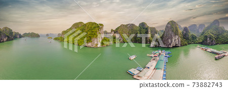 Aerial view panorama of floating fishing village and rock island, Halong Bay, Vietnam, Southeast Asia. UNESCO World Heritage Site. Junk boat cruise to Ha Long Bay. Popular landmark of Vietnam 73882743