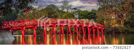 BANNER, LONG FORMAT Hanoi Red Bridge at night. The wooden red-painted bridge over the Hoan Kiem Lake connects the shore and the Jade Island on which Ngoc Son Temple stands BANNER, LONG FORMAT Hanoi Red Bridge at night. The wooden red-painted bridge over the Hoan Kiem Lake connects the shore and the Jade Island on which Ngoc Son Temple stands 73882827