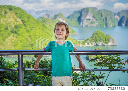 Boy traveler in Halong Bay. Vietnam. Travel to Asia, happiness emotion, summer holiday concept. Picturesque sea landscape. Ha Long Bay, Vietnam. After coronavirus COVID 19 73882880