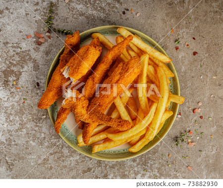 Tasty ccrunchy chicken nuggets with french fries on green ceramic plate Tasty ccrunchy chicken nuggets with french fries on green ceramic plate 73882930