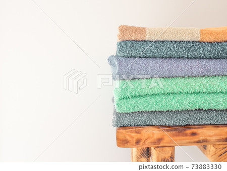 Lots of colorful bath towels stacked on each other. Isolated cotton towels for hotels, home, bathroom, kitchen 73883330