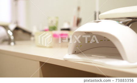 Nail lamp on a blue background. Place for text 73883356