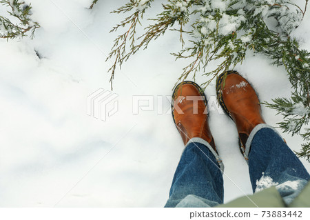 Woman in jeans and boots standing outdoor in winter 73883442