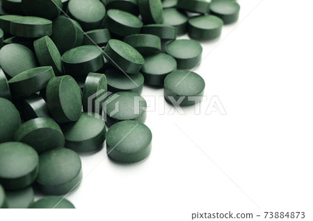 Spirulina in pills isolated on white background Spirulina in pills isolated on white background 73884873