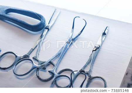Old surgical metal medical devices on wooden table 73885146