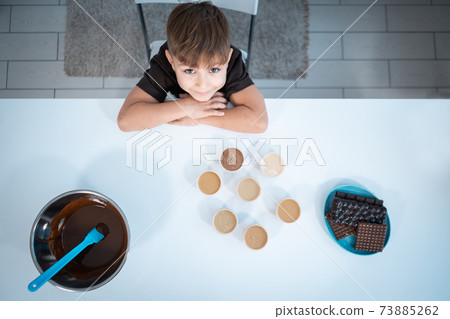 top view of smiling kid making chocolate bars or sweets at home kitchen 73885262