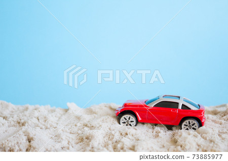 Red toy car, Summer concept. Car on a sandy beach 73885977