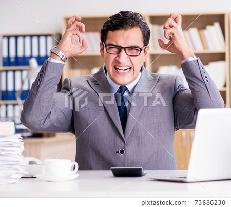 Angry businessman with too much work in office 73886230