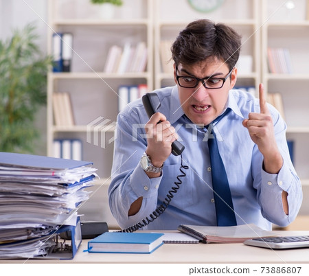 Businessman frustrated at many telephone calls 73886807