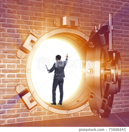 Businessman in front of banking vault door 73886845