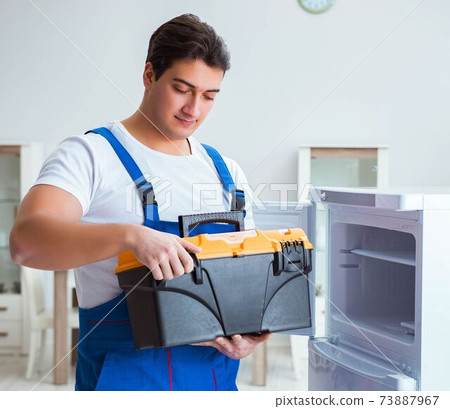 Repairman contractor repairing fridge in DIY concept Repairman contractor repairing fridge in DIY concept 73887967
