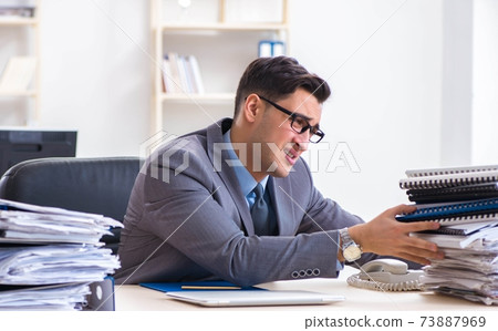 Overloaded with work employee under paperwork burden Overloaded with work employee under paperwork burden 73887969