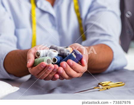 Young man tailor working on new clothing Young man tailor working on new clothing 73887976