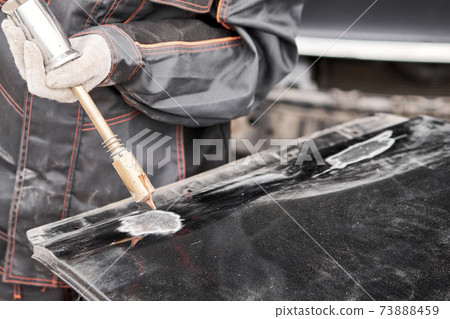 Spotter, a Welding machine for straightening dents on the car body. spot welding of metal. Repair service worker fix damaged car. 73888459