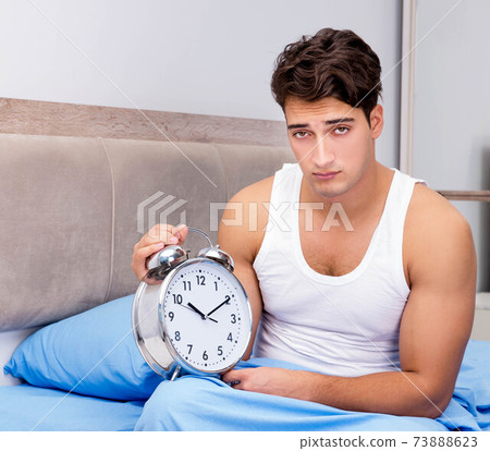 Man having trouble waking up in morning Man having trouble waking up in morning 73888623