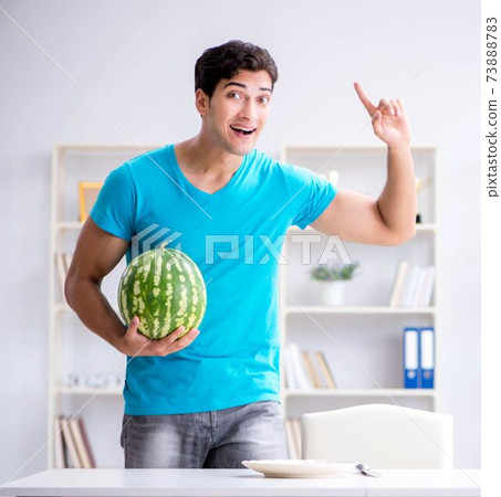 Man eating watermelon at home 73888783