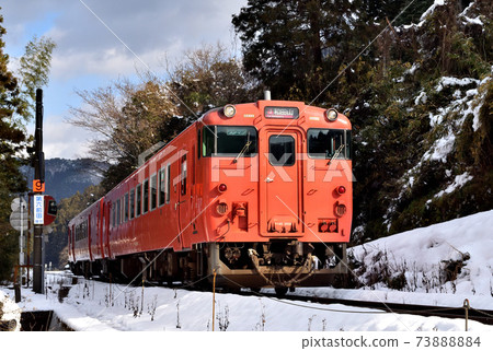 在白雪皚皚的景觀中運行的紅色柴油車 73888884