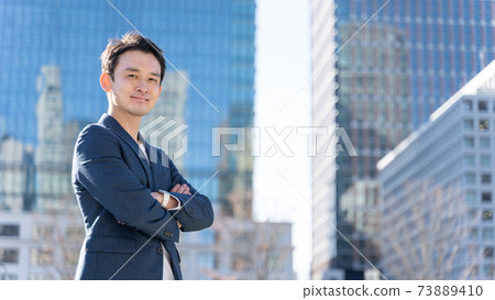 A businessman standing in an office town A businessman standing in an office town 73889410