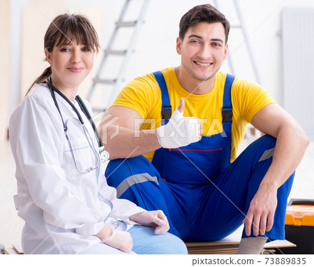 Injured worker being assisted by doctor 73889835