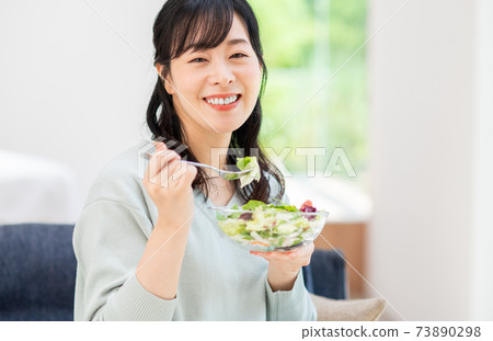Middle-aged woman eating a salad Middle-aged woman eating a salad 73890298