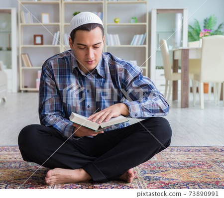 Young muslim man praying at home 73890991