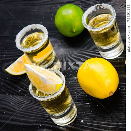 Tequila drink served in glasses with lime and salt 73891158