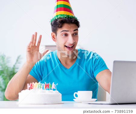 Young man celebrating birthday alone at home Young man celebrating birthday alone at home 73891159