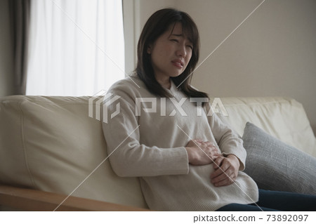 Image of a woman with abdominal pain and poor physical condition Image of a woman with abdominal pain and poor physical condition 73892097