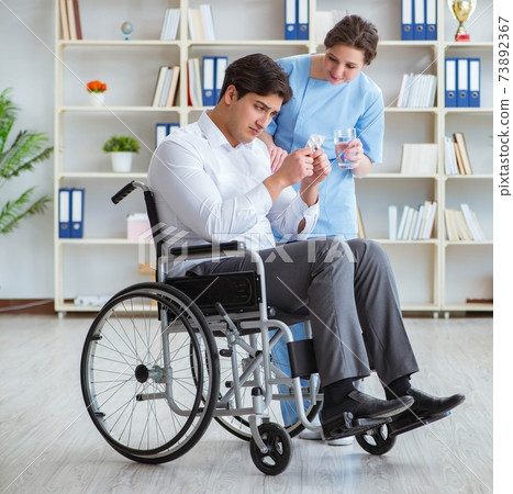 Disabled patient on wheelchair visiting doctor for regular check Disabled patient on wheelchair visiting doctor for regular check 73892367