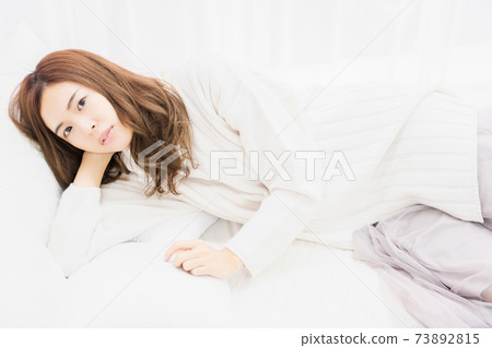 躺在床上，她的手肘的年輕女子 73892815