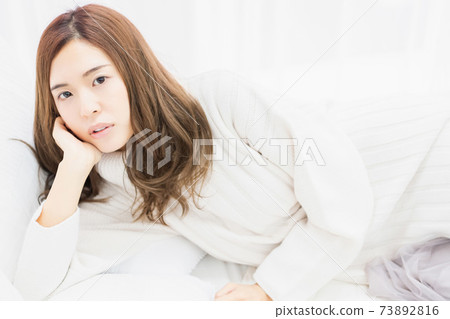 躺在床上,她的手肘的年輕女子 躺在床上,她的手肘的年輕女子 73892816