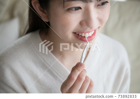 Women using an interdental brush 73892833