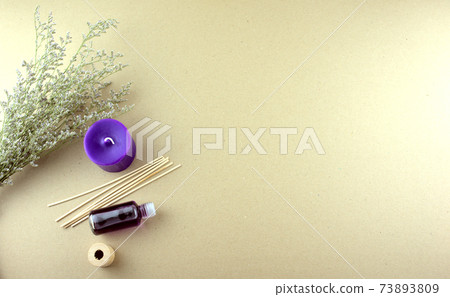 Lavender scent oil in bottle with purple candles, wooden sticks and dry flowers flat lay on table. Aromatherapy, spa, massage or improving psychological well-being concepts. Minimal style. Copy space. Lavender scent oil in bottle with purple candles, wooden sticks and dry flowers flat lay on table. Aromatherapy, spa, massage or improving psychological well-being concepts. Minimal style. Copy space. 73893809