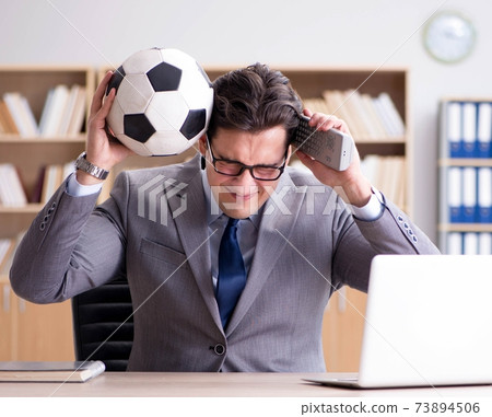 Businessman with football ball in office 73894506