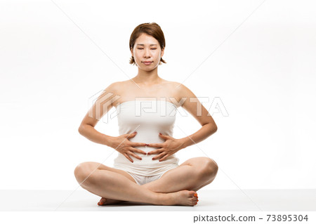 A woman holding her tummy 73895304