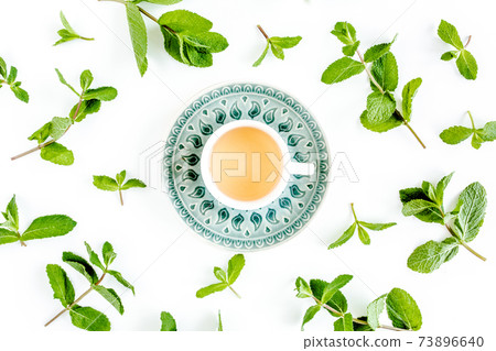 Mint tea with frame made of mint leaves isolated on white background. Set of peppermint. Mint Pattern. Flat lay. Top view. Mint tea with frame made of mint leaves isolated on white background. Set of peppermint. Mint Pattern. Flat lay. Top view. 73896640