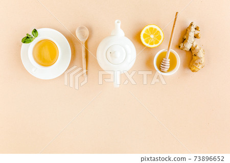 Herbal tea with mint, ginger, lemon, honey and other herbs on yellow background. Flat lay, top view. Herbal tea with mint, ginger, lemon, honey and other herbs on yellow background. Flat lay, top view. 73896652