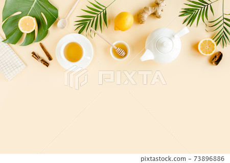 Herbal tea with mint, ginger, lemon, honey and other herbs on yellow background. Flat lay, top view. Herbal tea with mint, ginger, lemon, honey and other herbs on yellow background. Flat lay, top view. 73896886