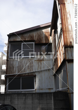 Rusted factory wall made of galvanized iron / construction site / town factory / ruins 73898312