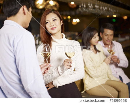 young asian couple relaxing in pub young asian couple relaxing in pub 73899668