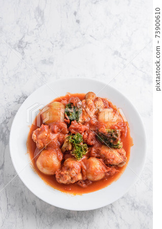 Stewed chicken wings and small onions in tomato sauce Stewed chicken wings and small onions in tomato sauce 73900610