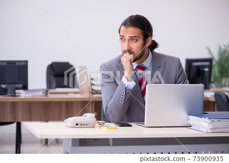Young male employee working in the office Young male employee working in the office 73900935