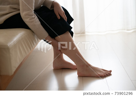 照顧腿部腫脹的婦女,按摩小腿的婦女 照顧腿部腫脹的婦女,按摩小腿的婦女 73901296
