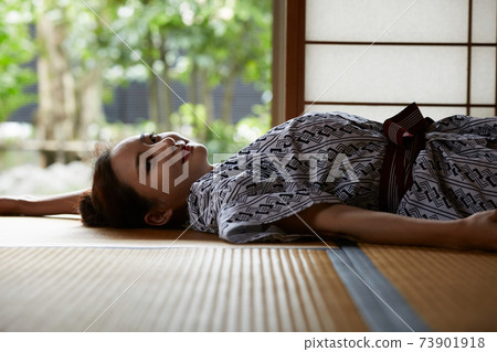 A young woman in a yukata relaxing at an inn 73901918