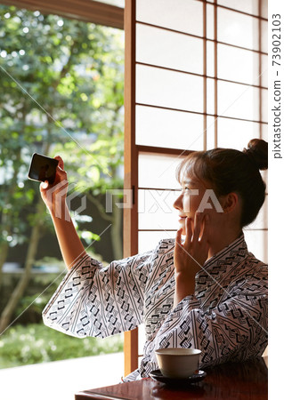 A young woman in a yukata relaxing at an inn A young woman in a yukata relaxing at an inn 73902103