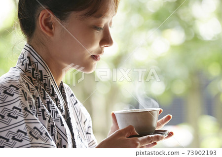 A young woman in a yukata relaxing at an inn A young woman in a yukata relaxing at an inn 73902193