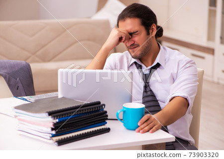 Young male employee working from home during pandemic 73903320